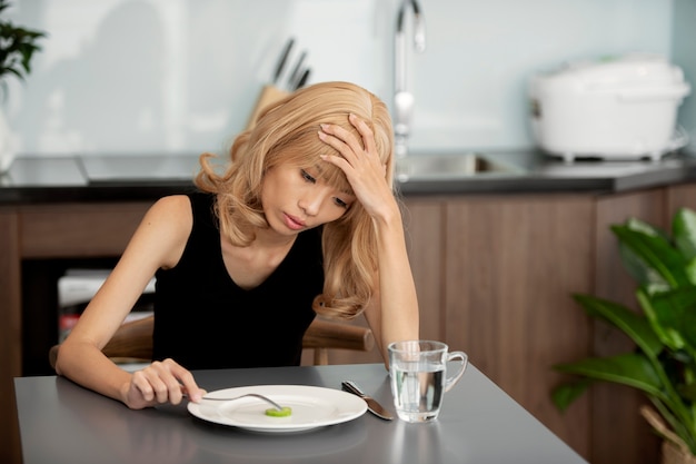 食べるのに苦労しているミディアムショットの女性