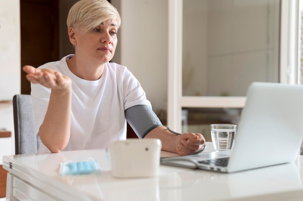 写真 オンラインで医者と話しているミディアムショットの女性