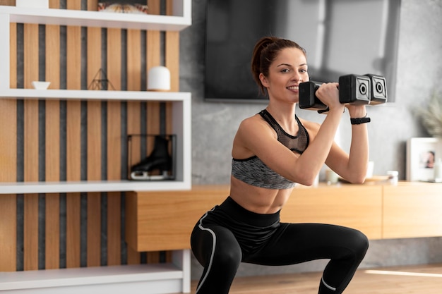 Medium shot woman training with dumbbells