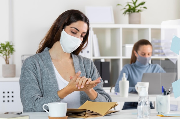 Foto donna del colpo medio che utilizza disinfettante