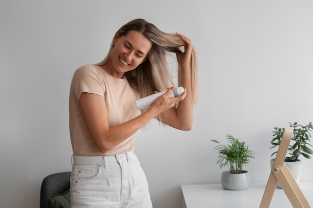 Foto donna di tiro medio che usa shampoo a secco a casa