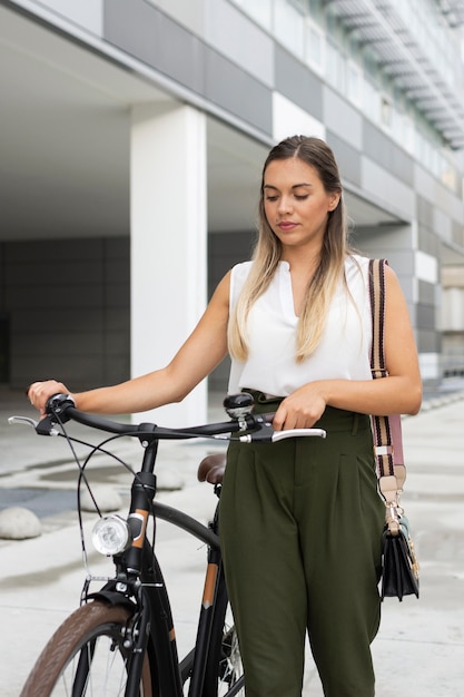 Photo medium shot woman walking next to bike