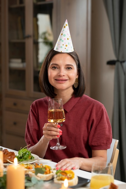 写真 誕生日の帽子とミディアムショットの女性