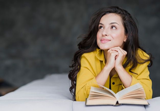 Donna del colpo medio con distogliere lo sguardo del libro