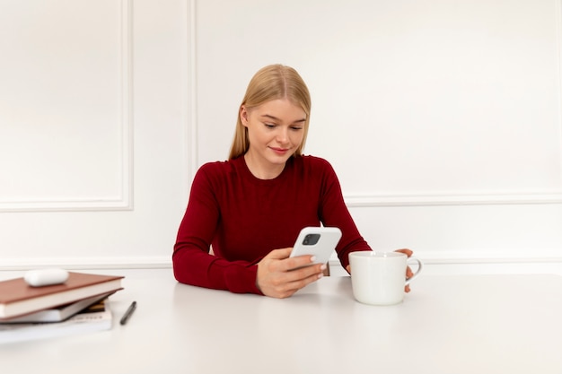 Photo medium shot woman with cup and smartphone