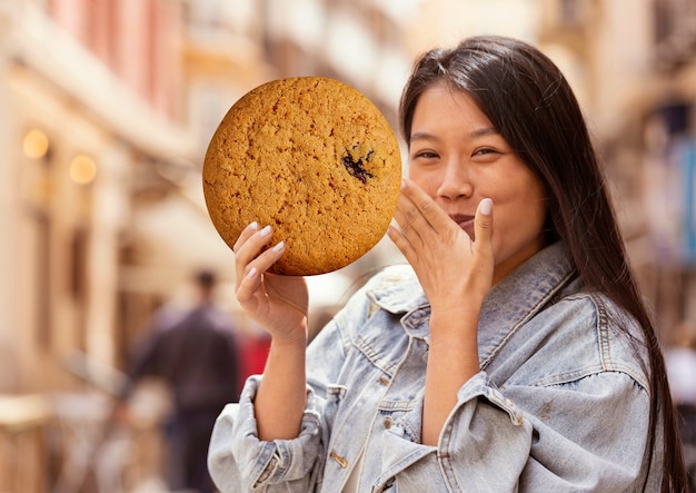 巨大なクッキーを持つミディアムショットの女性