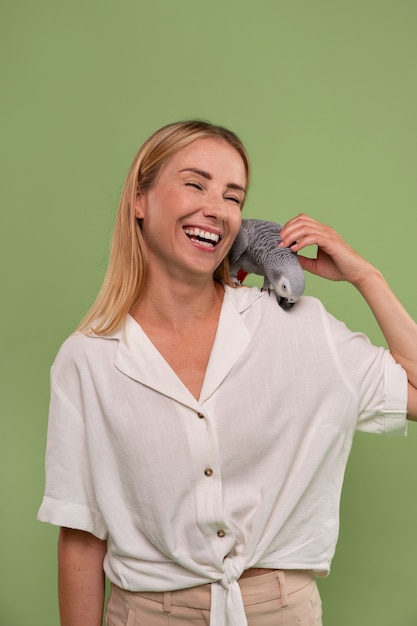 Photo medium shot woman with parrot in studio