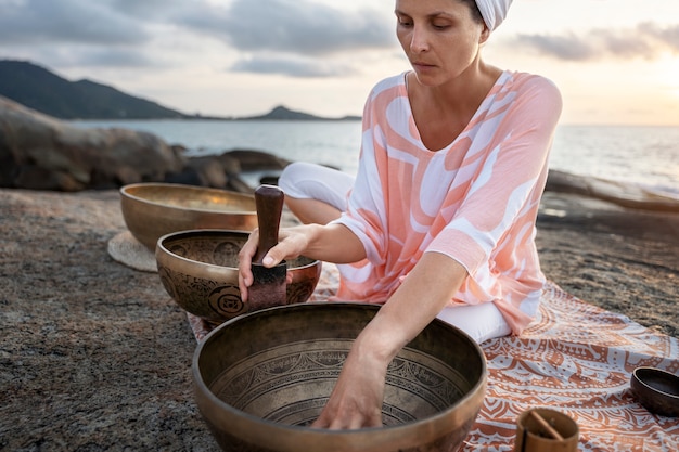 Photo medium shot woman with singing bowls outdoors