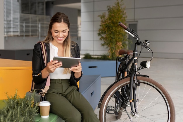 タブレットと自転車でミディアムショットの女性