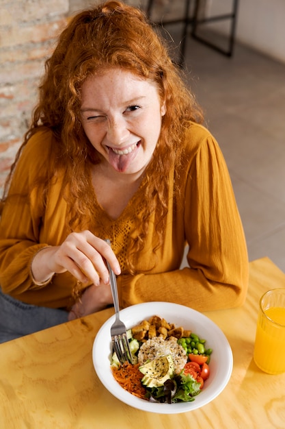 Medium shot woman with vegetarian food