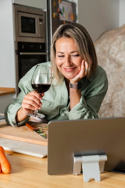 Donna del colpo medio con un bicchiere di vino