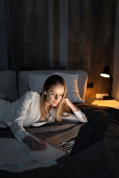 Medium shot woman working on laptop