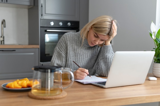 Medium shot woman working with laptop