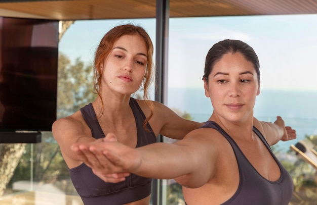 Foto donne del colpo medio che fanno yoga insieme