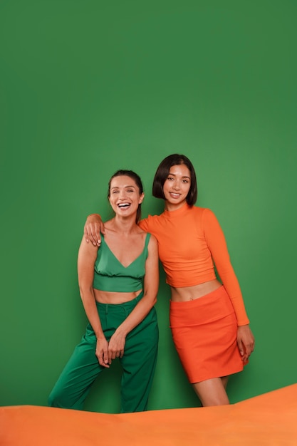 Фото Женщины среднего размера позируют на зеленом фоне