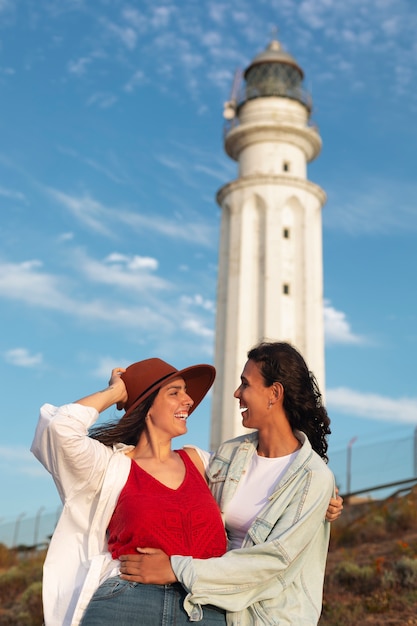 写真 灯台とポーズをとっている中型の女性