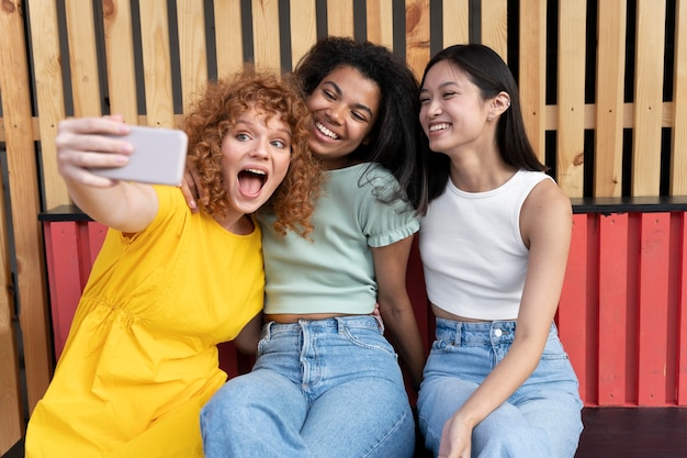 Medium shot women taking selfie