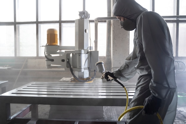 medium shot worker spraying powder paint
