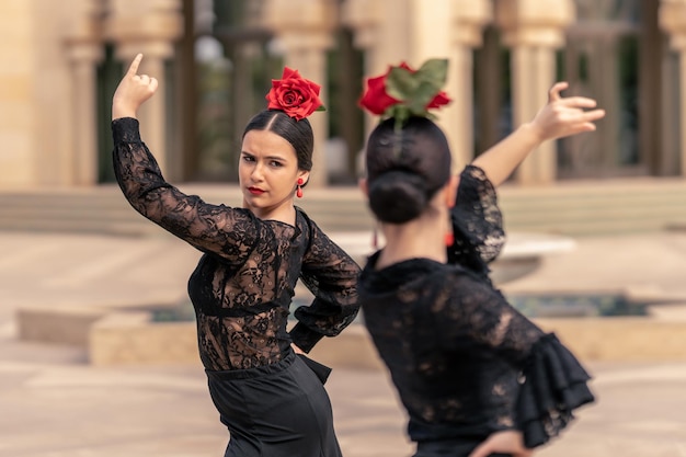 Photo medium shot of a young flamenco dancer dressed in black dancing with her partner