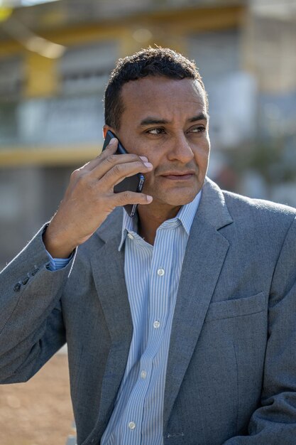 Medium shot of a young latino man talking on the phone