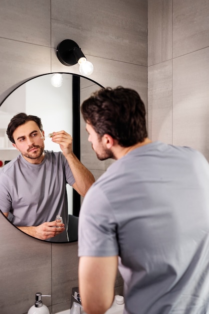 Photo medium shot young man applying serum