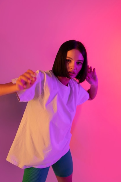 Medium shot young woman posing in pink light