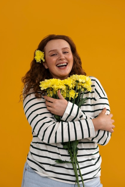 Medium shot young woman posing with flowers