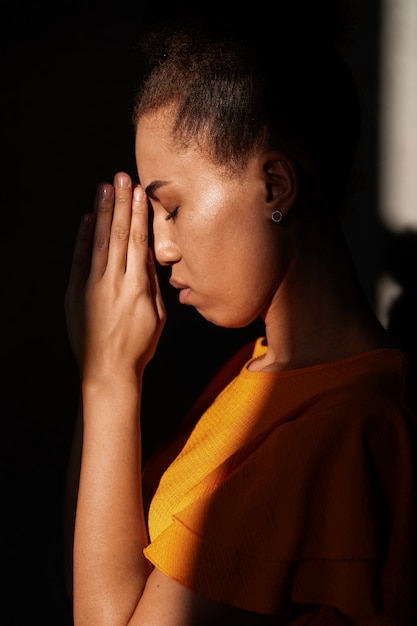 Medium shot young woman praying