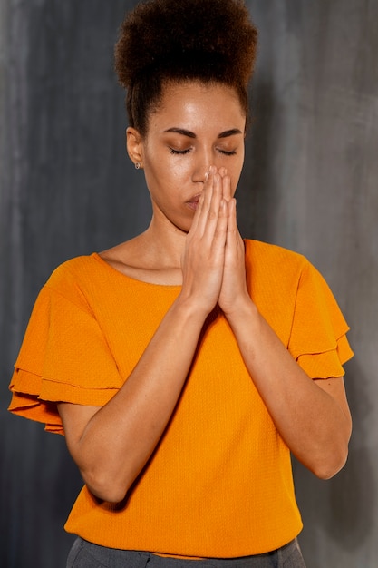 Medium shot young woman praying