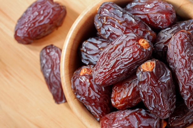 Medjool dadels in houten kom op tafel, bovenaanzicht. Zeer voedzaam fruit verhoogt de moedermelk voor moeders die borstvoeding geven.