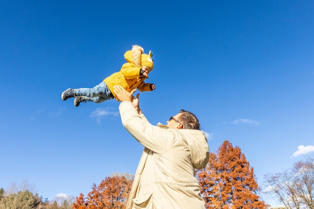 Meer meer vader dat is leuk gelukkige jonge vader gooit zijn schattige kleine jongen in de lucht vadersdag