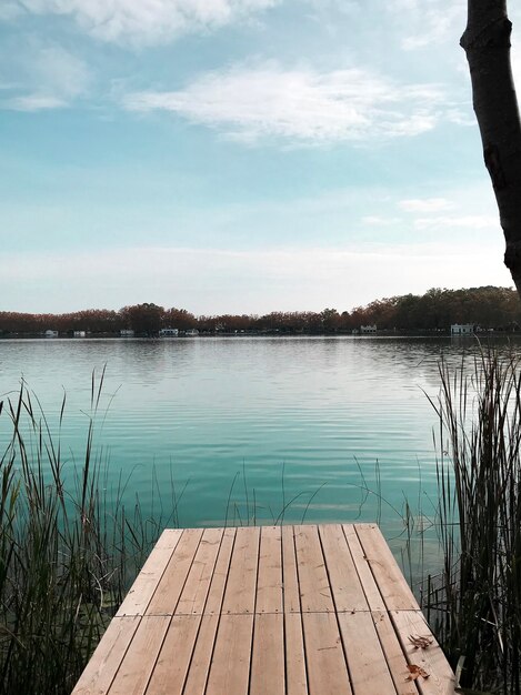 Foto meer met rustig water en houten loopbrug