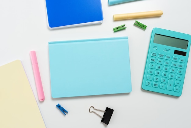 Meerdere geassorteerde collectie Kantoorbenodigdheden Foto Met Pennen Potloden Blocnotes Notebook Liniaal Nietmachine Schaar Clippers Paperclips Houders Klembord boven tafel geplaatst
