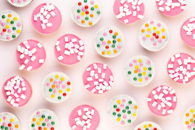 Meerdere kleurrijke mooi ingerichte muffins op een witte achtergrond bovenaanzicht