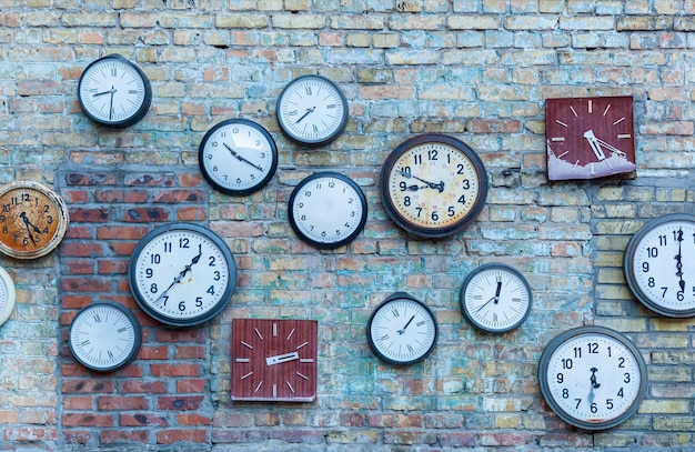 Meerdere klok. Veelheid van de verschillende klokken op de oude bakstenen muur.