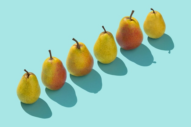 Meerdere peren op een rij op een blauwe achtergrond