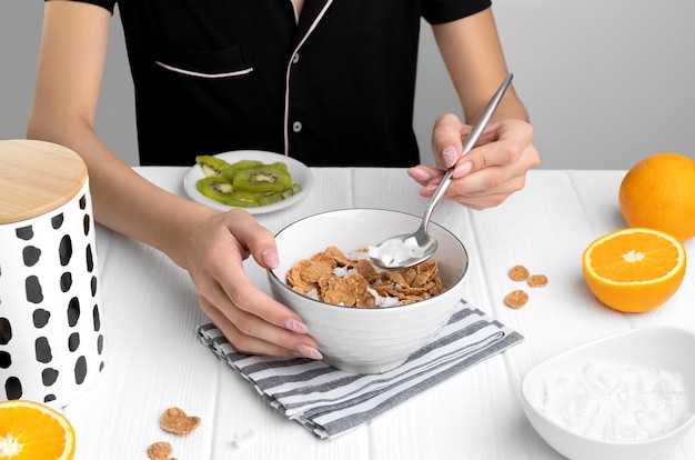 Meergranen vlokken met sinaasappel en kiwi fruit en kokos in kom