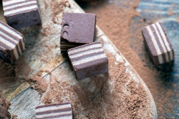 Foto meerlaagse snoepjes gemaakt van room en chocolade lagen met verschillende smaken gemengde smaak van snoep van verschillende ingrediënten in gestreepte snoepjes