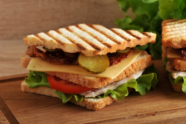 Meerlagige sandwich met kaas, ham, tomaten, augurken en sla gefotografeerde close-up