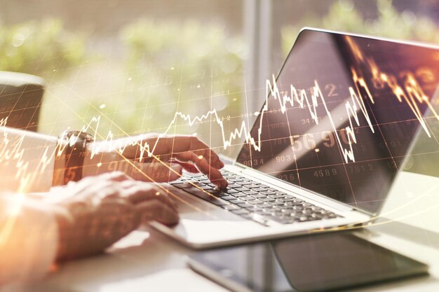 Meervoudige blootstelling van abstracte creatieve financiële grafiek met hand typen op laptop op achtergrond forex en investeringsconcept