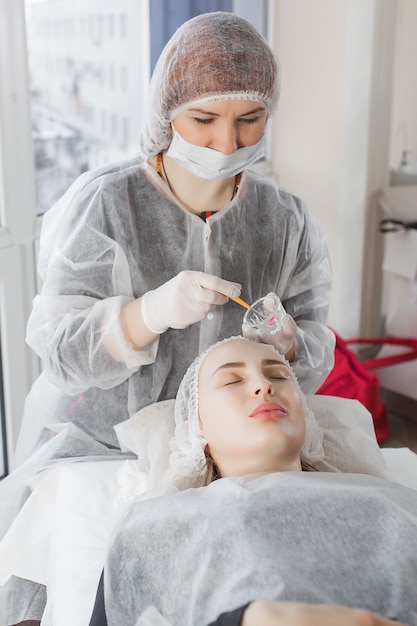 Meester die een cosmetische procedure maakt voor haar cliënt. huidverzorging. vrouw die een gezichtsverzorging procedure.