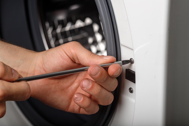 Meester loodgieter die een wasmachine in de badkamer bevestigt, close-up