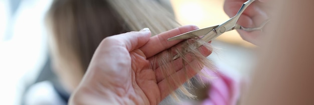 Meesterkapper knipt gespleten haarpunten met een schaarclose-up