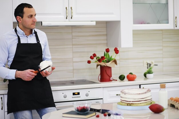 Meesterpatissier voor een bureau. Thuis desserts koken. De Armeense man houdt zich bezig met zoetwaren.