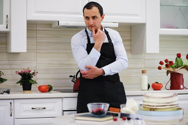 Meesterpatissier voor een bureau. Thuis desserts koken. De Armeense man houdt zich bezig met zoetwaren.