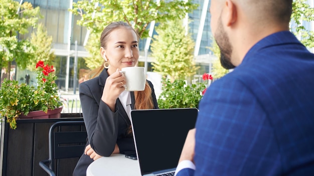 Meeting of business partners in a cafe, discussing a project outside the office. Kazakh businessman and businesswoman create enterprise start up team