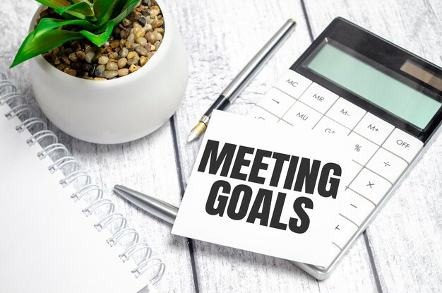 MEETING GOALS text on sticker with calculator glasses and magnifier