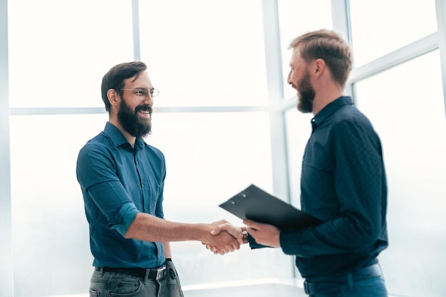 Meeting and shaking hands with business people in a bright office