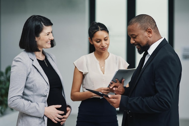 Meetings on the move made easy with mobile tech Shot of a group of businesspeople using a digital tablet during a meeting in a modern office