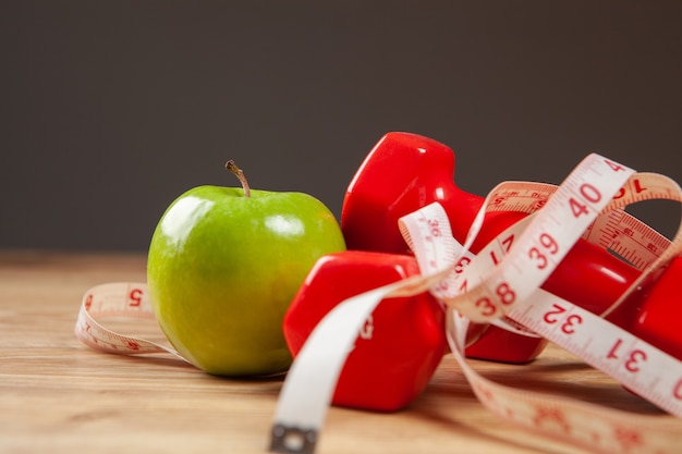 Meetlint, appel en dumbbells op tafel